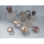 A COLLECTION OF CUT-GLASS SILVER TOPPED BOTTLES AND JARS (8)