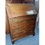 A GEORGE III STYLE OAK BUREAU OF SMALL PROPORTIONS