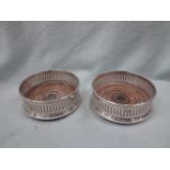 A PAIR OF SILVER BOTTLE COASTERS