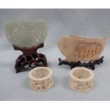 A SMALL CHINESE JADE PLAQUE ON A WOODEN STAND