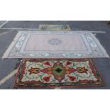 A LARGE PINK CHINESE RUG AND TWO WOOLEN RUGS