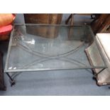 A CONTEMPORARY WROUGHT IRON AND GLASS-TOPPED COFFEE TABLE