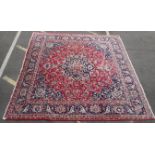 A LARGE RED GROUND PERSIAN DESIGN RUG