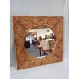 A CIRCULAR MIRROR, IN A CARVED HARDWOOD FRAME