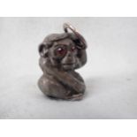 A CAST METAL MONKEY, POSSIBLY JAPANESE, WITH 'GARNET' EYES