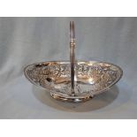 AN UNMARKED WHITE METAL SWING-HANDLED DISH