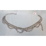 A WHITE METAL BELLY DANCING CHAIN BELT, WITH BELLS
