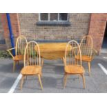 AN ERCOL DROP-LEAF DINING TABLE AND FOUR CHAIRS