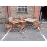 TWO TEAK FOLDING GARDEN TABLES AND SIX CHAIRS