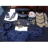 A COLLECTION OF MILITARY HATS, BADGES AND BUTTONS