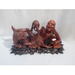 AN ASIAN WOODEN STATUE WITH STAND