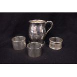 THREE SILVER NAPKIN RINGS WITH A BARREL FORM SILVER MUG