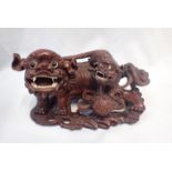 A CHINESE CARVED HARDWOOD LION DOG SCULPTURE