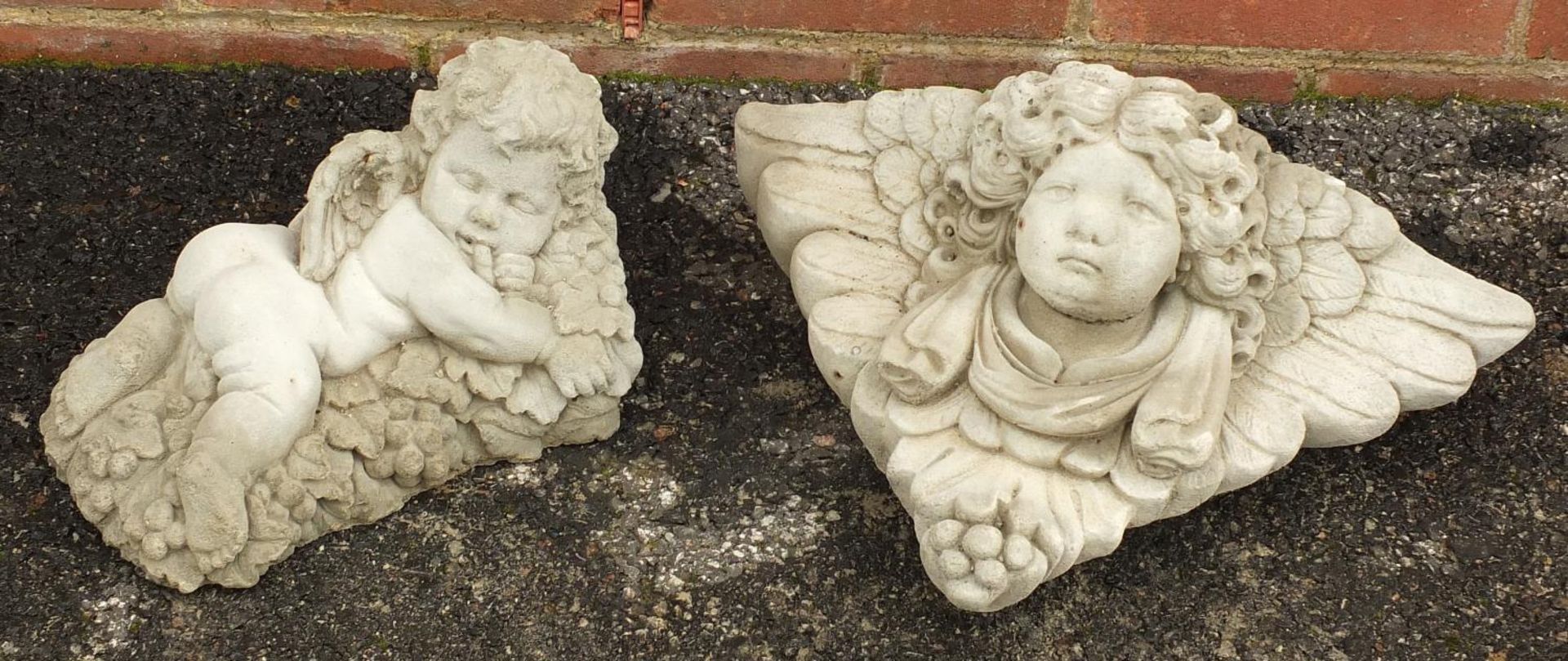 Stoneware garden figure of Putti and a Putti wall pocket, the largest 40cm wide