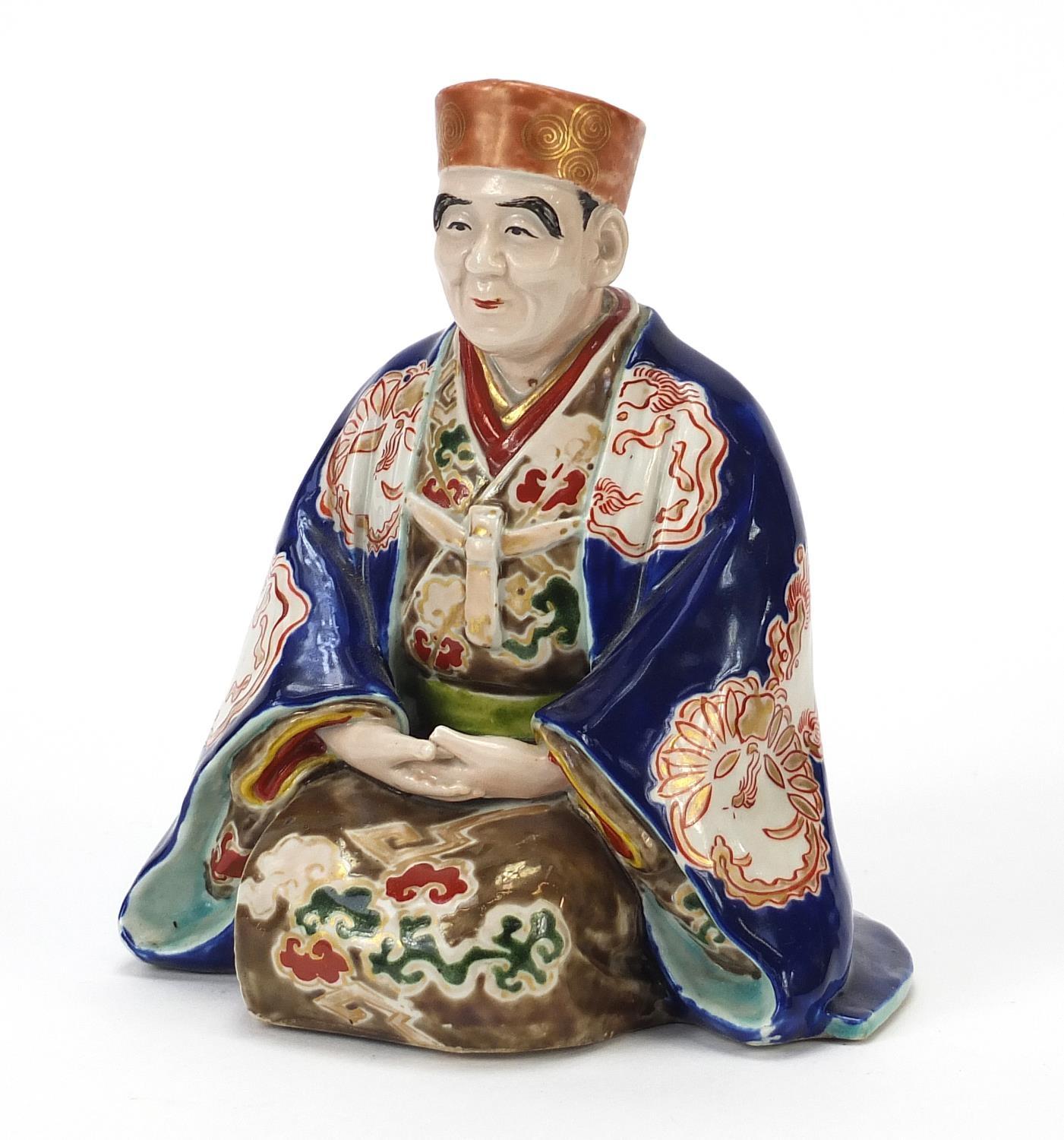 Japanese porcelain figure of a seated robed man, 17cm high