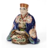 Japanese porcelain figure of a seated robed man, 17cm high