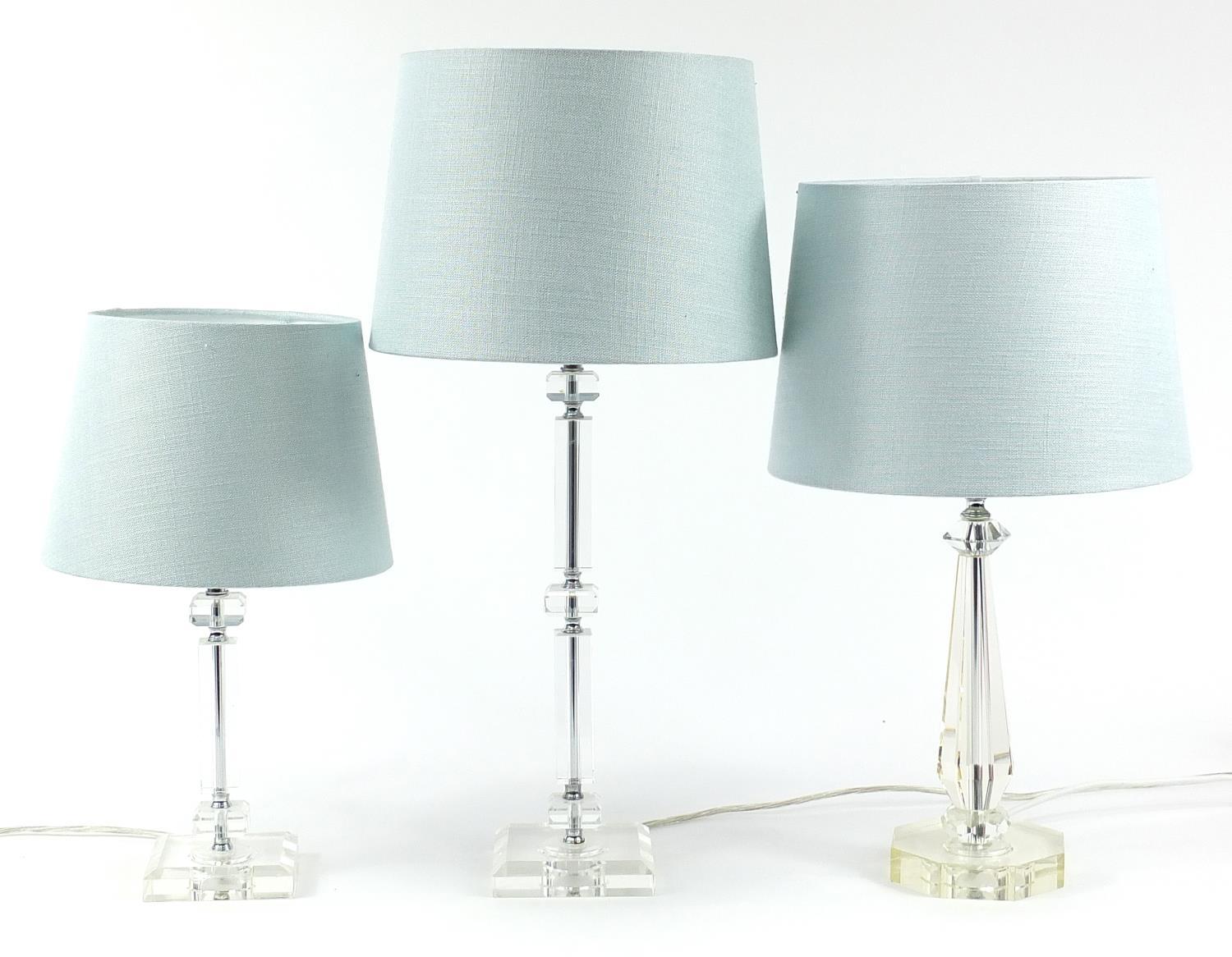 Three contemporary glass table lamps with teal shades, the largest 63cm high