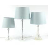 Three contemporary glass table lamps with teal shades, the largest 63cm high