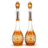 Pair of Bohemian amber flashed cut glass decanters with silver collars, each 43cm high