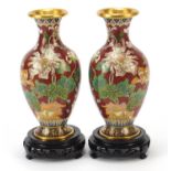 Pair of Chinese cloisonné vases enamelled with birds amongst blossoming flowers, each raised on