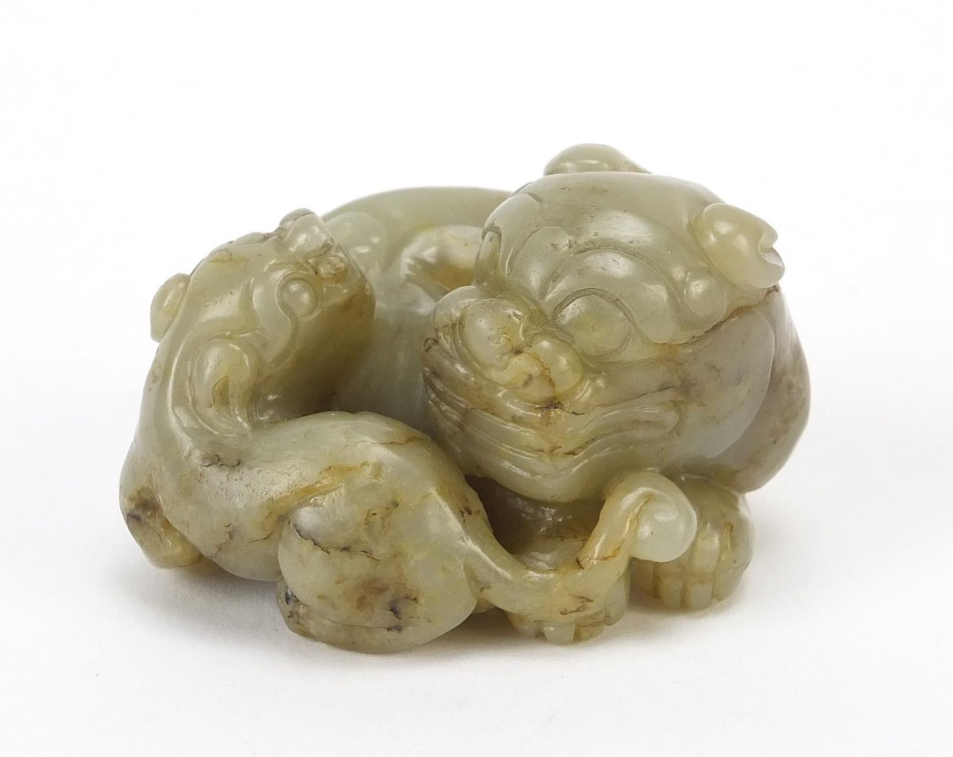 Chinese celadon and russet jade carving of two mythical lions, 6cm wide