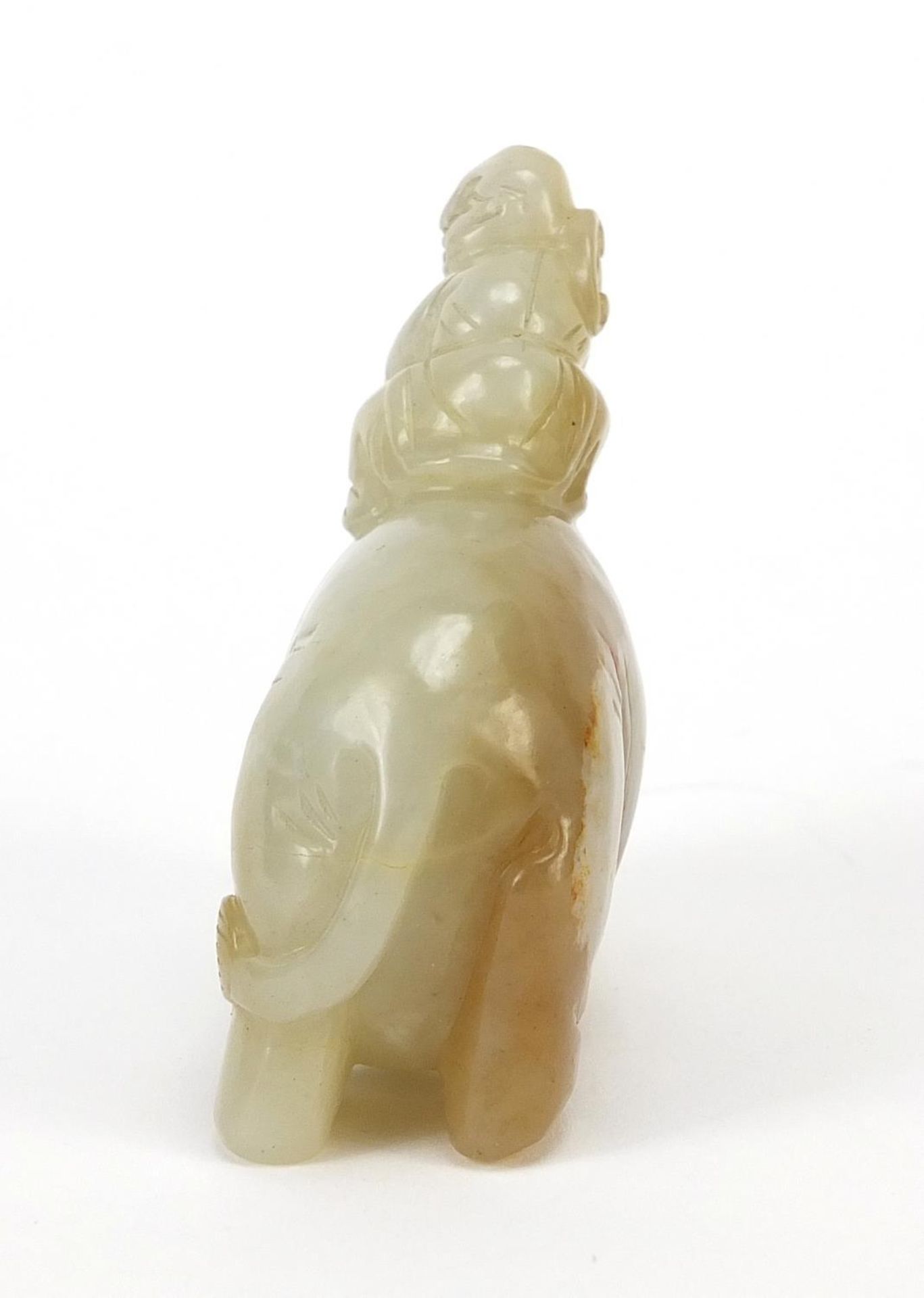 Chinese celadon and russet jade carving of a boy holding a ruyi sceptre on elephant, 6.5cm wide - Image 3 of 7