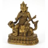 Chino Tibetan patinated gilt bronze figure of an Emperor on mythical animal, 23.5cm high