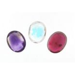 Three gemstones, comprising ruby, amethyst and topaz, each approximately 10mm x 8.0mm x 5mm deep