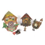 Three carved Black Forest cuckoo clocks, one with pendulum, the largest 22cm high
