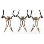 Three silver monkey pendants on cord necklaces, the pendants 4cm high