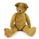 Large golden straw filled teddy bear with jointed limbs, 89cm high