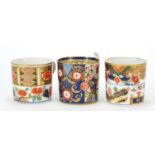 Three early 19th century Derby porcelain coffee cans hand painted in the Imari palette, the