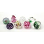 Eight colourful glass paperweights including a purple Bohemian overlaid, Caithness and Langham,