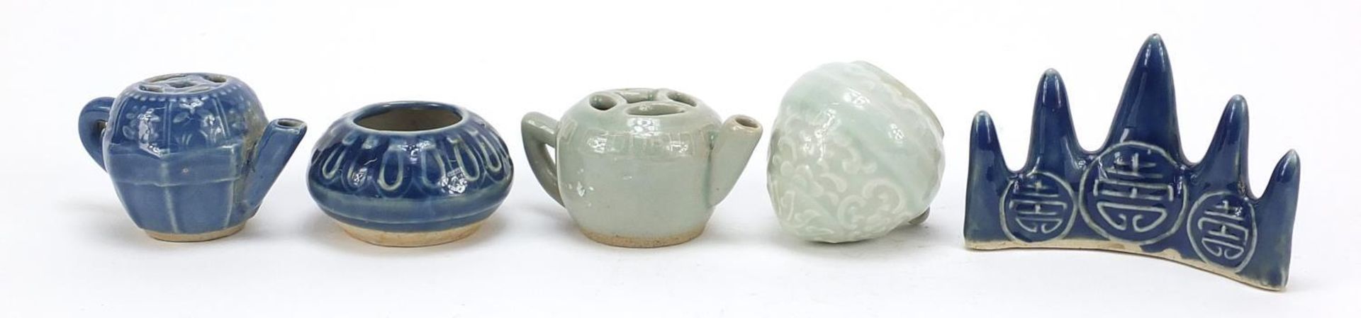 Chinese porcelain including a blue glazed brush rest and two teapots, the largest 9.5cm wide