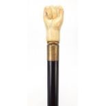 Hardwood walking stone with carved bone clench fist design pommel, 93.5cm in length