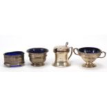 Three silver open salts with blue glass liners and a silver mustard with green glass liner,
