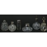Six Victorian and later cut glass bottles and an inkwell with silver and silver plated mounts, the