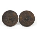 Pair of Afghan cast iron hand mirrors cast with mythical beasts, each 11cm in diameter