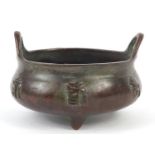 Chinese patinated bronze censer with twin handles and character marks to the base, 8cm in diameter