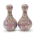 Pair of Chinese porcelain garlic head hexagonal vases, profusely decorated with flowers, four figure