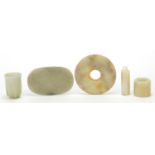 Chinese white, celadon and russet jade carvings including a bi disc and cup, the largest 9.5cm wide