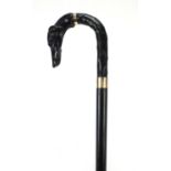 Ebonised walking stick with dog's head design handle and gold coloured metal mounts, 92cm in length