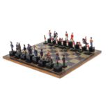 Hand painted metal Waterloo chess set with board, the largest pieces each 11cm high, the board