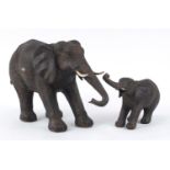 Two leather style model elephants, the largest 52cm in length