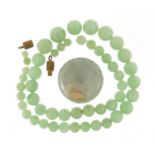 Chinese green jade bead necklace and a large bead, the largest approximately 2.8cm in diameter