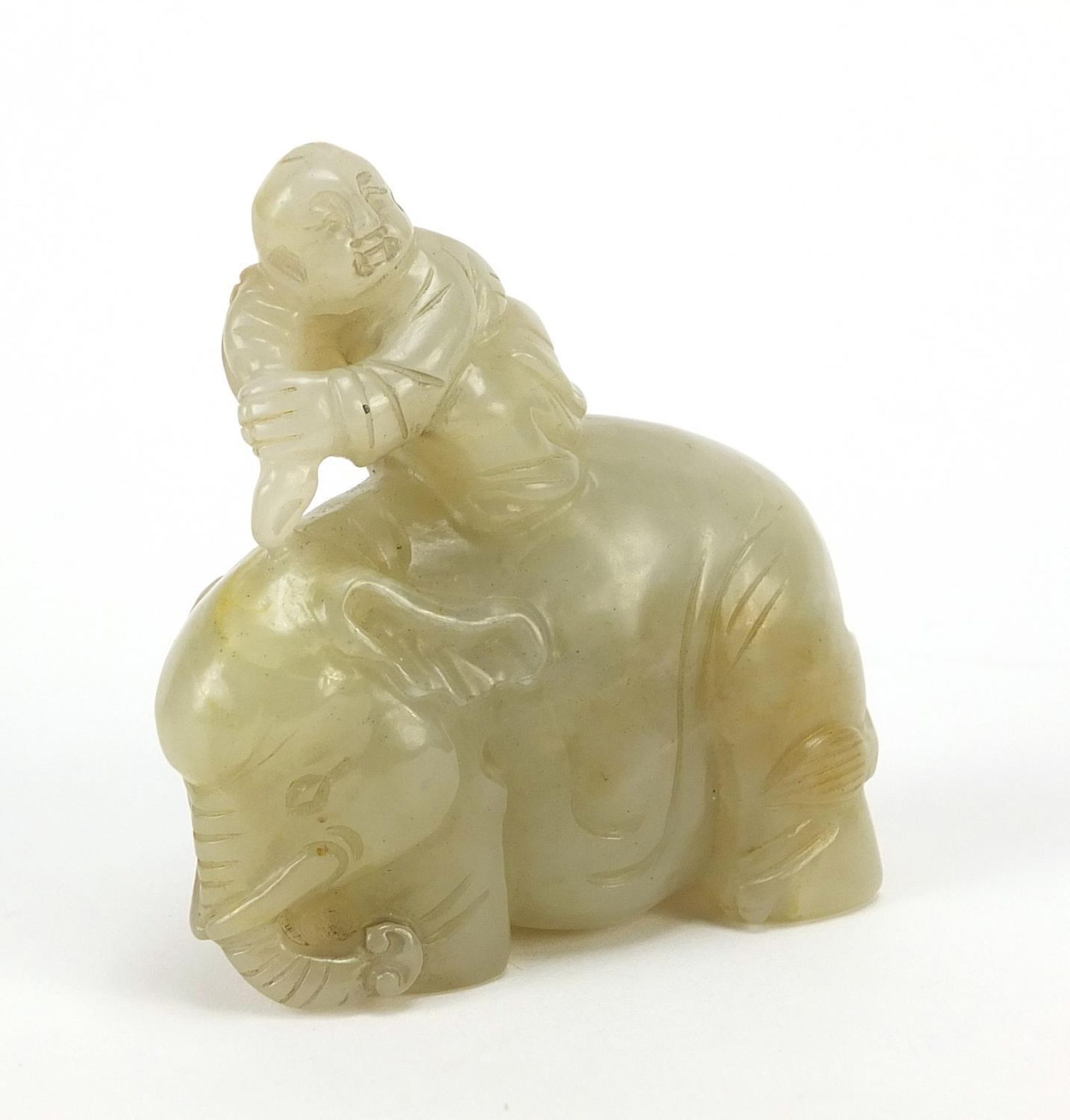 Chinese celadon and russet jade carving of a boy holding a ruyi sceptre on elephant, 6.5cm wide