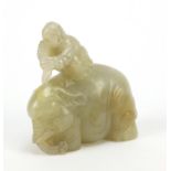 Chinese celadon and russet jade carving of a boy holding a ruyi sceptre on elephant, 6.5cm wide