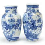 Matched pair of Japanese blue and white porcelain vases hand painted with flowers, each 26cm high