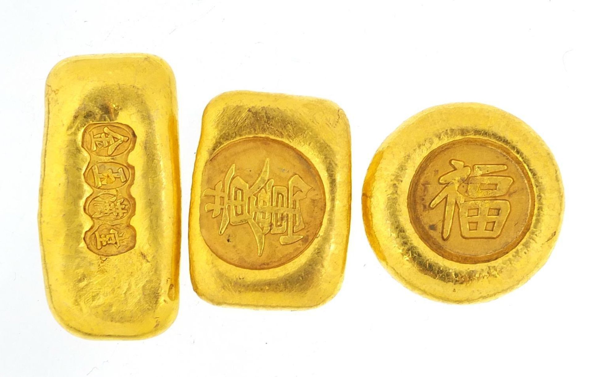 Three Chinese gold coloured metal ingots, the largest 4.5cm wide