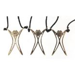 Three silver monkey pendants on cord necklaces, the pendants 4cm high